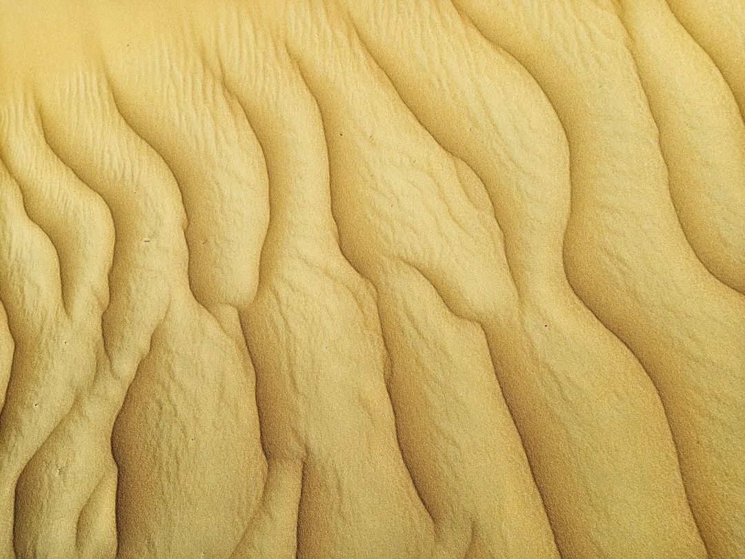 Bàn tay đang dùng giấy nhám chà vào cạnh cửa gỗ