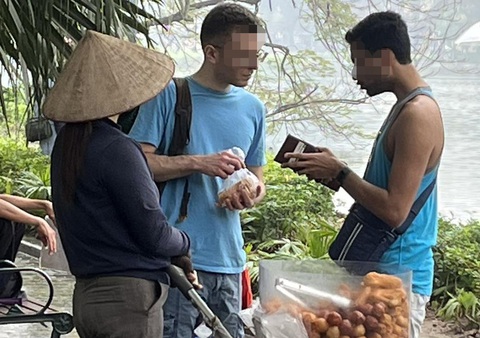 Du khách trò chuyện với người bán hàng rong