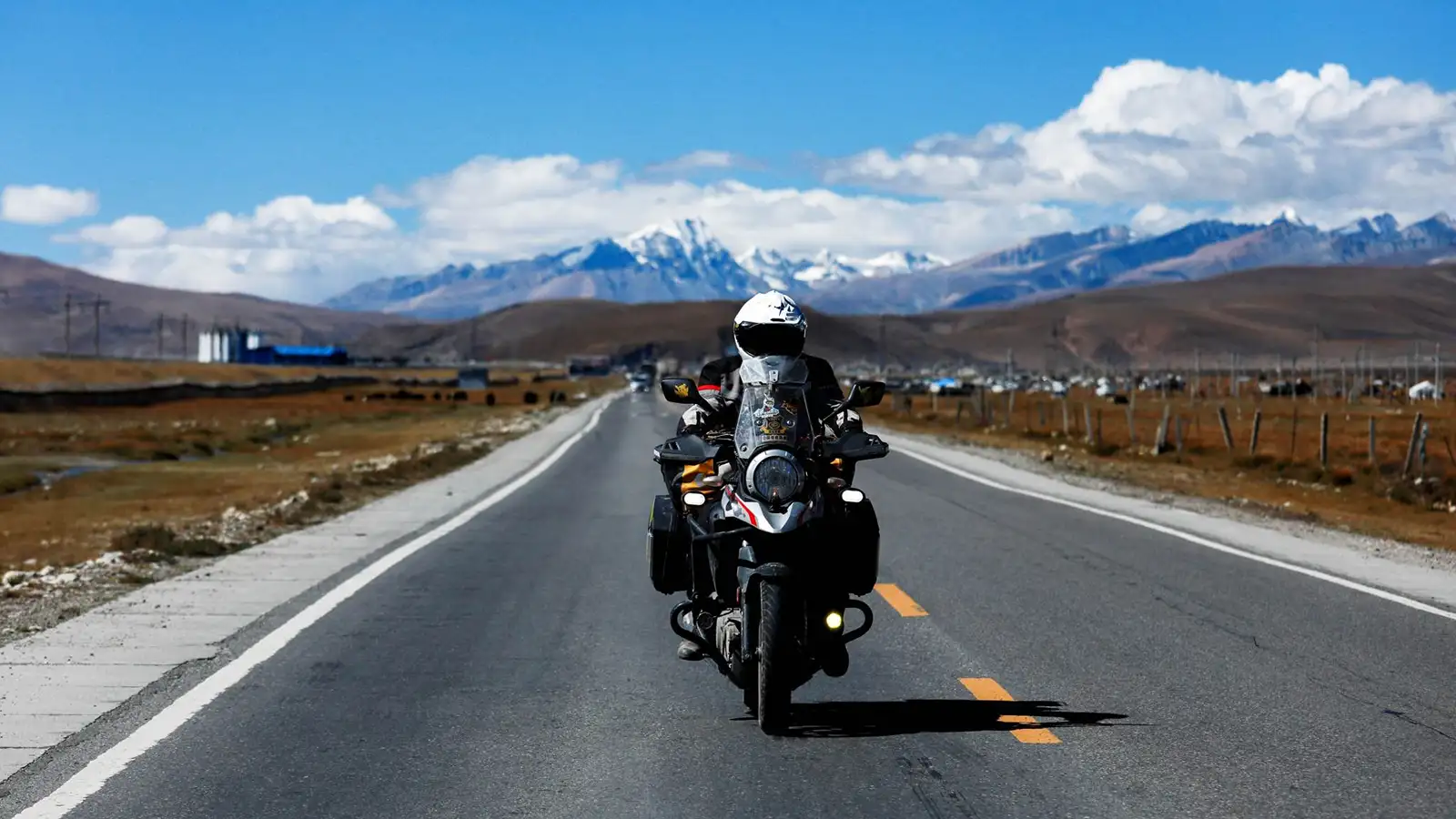 Người lái xe máy mặc đồ bảo hộ, đội mũ bảo hiểm trên đường đèo