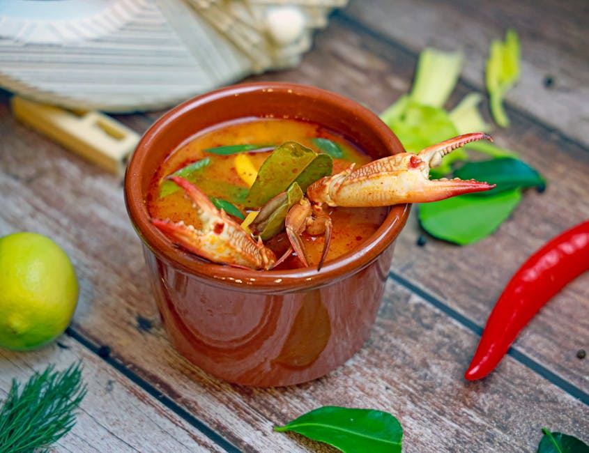 Bát canh chua cá đã hoàn thành, rắc rau thơm và ớt